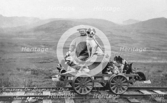 Man and dogs on rail cart trip from Shelton to Nome, 1912. Creator: Unknown.