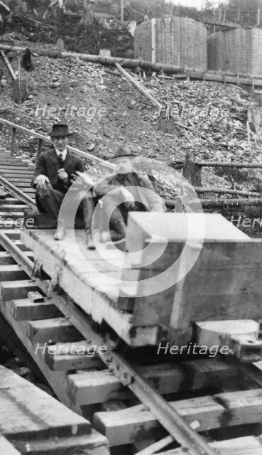 Frank G. Carpenter and man sitting on tracks, between c1900 and 1924. Creator: Unknown.