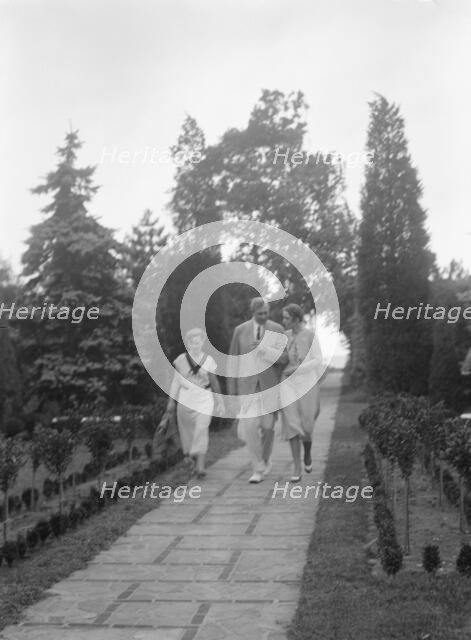 Edge, Charles N., walking with Margaret Edge and another woman in his garden, 1932 or 1933. Creator: Arnold Genthe.