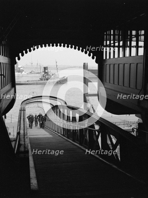 Men walking up a wooden bridge on a river, c1945-c1965.  Artist: SW Rawlings