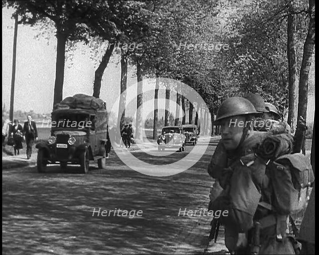French Refugees Fleeing Town Down Country Roads, British Forces Moving Past Them, 1940. Creator: British Pathe Ltd.