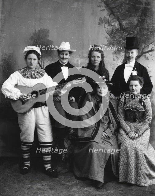 Six dressed-up youngsters, one of the young people plays the guitar, 1910-1920. Creator: Hans Per Persson.
