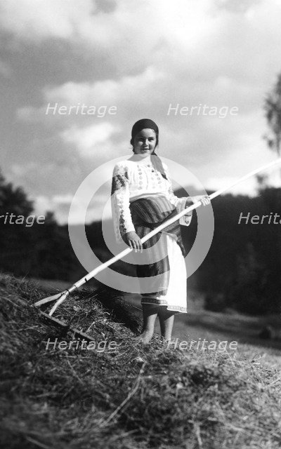 Young woman with a rake, Bistrita Valley, Moldavia, north-east Romania, c1920-c1945. Artist: Adolph Chevalier