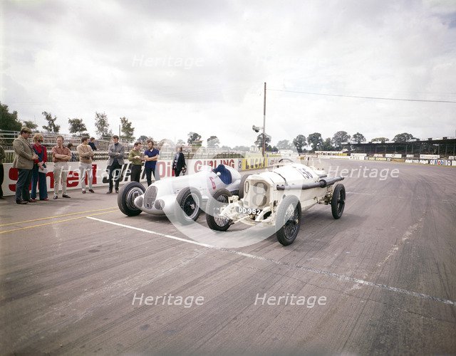 A 1914 and 1937 Grand Prix Mercedes racing cars at the starting line. Artist: Unknown