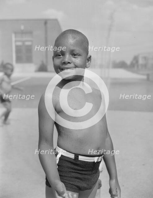 Cooling off under the community sprayer, Frederick Douglass housing project, Anacostia, D.C, 1942. Creator: Gordon Parks.