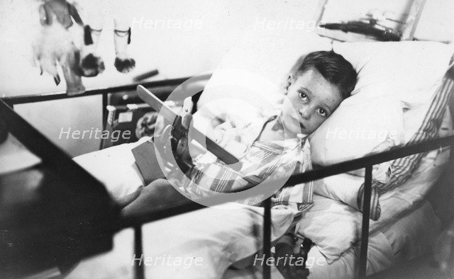 Greek boy from Pylos being nursed in the sick bay of the British battleship HMS 'Malaya', 1938. Artist: Unknown