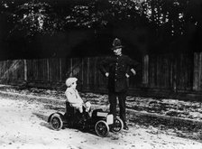 Boy in 1908 Mercedes pedal car. Artist: Unknown