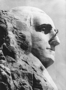 An engineer works on George Washington's head at Mount Rushmore, South Dekota. Artist: Unknown