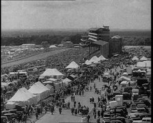 Large Crowd Sitting Outside with Cars and Tents, 1933. Creator: British Pathe Ltd.