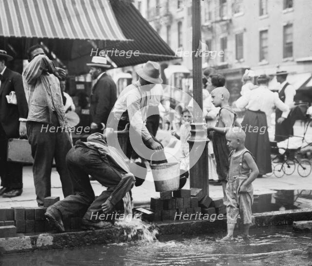 Summer scene, N.Y. - drinking water from street pump, between c1910 and c1915. Creator: Bain News Service.