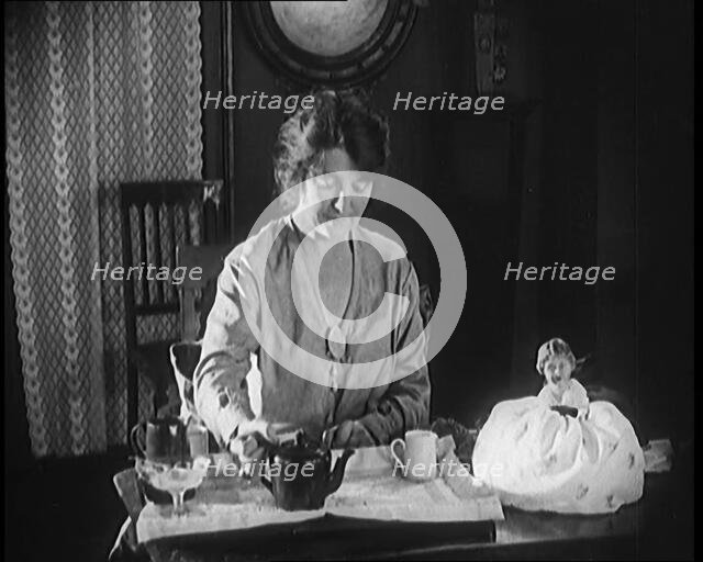 Female Civilian Seating at a Table Serving Tea, 1920. Creator: British Pathe Ltd.