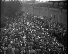 Masses of People Cheering - Many Have Umbrellas As It Is Raining, 1932. Creator: British Pathe Ltd.