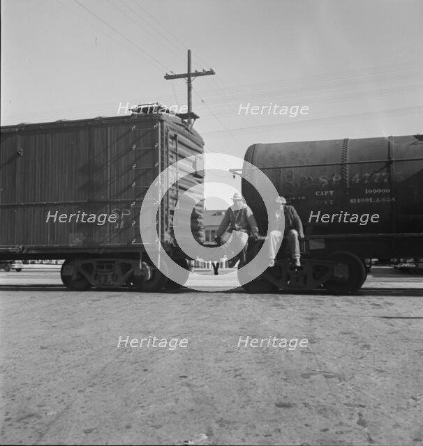 Colored itinerants on oil tank cars passing through Kingsbury, California, 1938. Creator: Dorothea Lange.