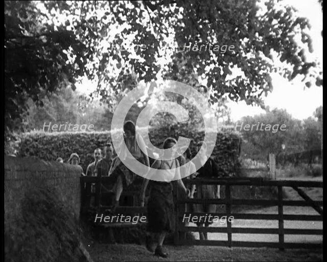 Hikers Climbing over a Gate, 1933. Creator: British Pathe Ltd.