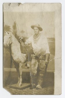 Postcard of a man posing in a Western scene in a photography studio, early 20th century. Creator: Unknown.