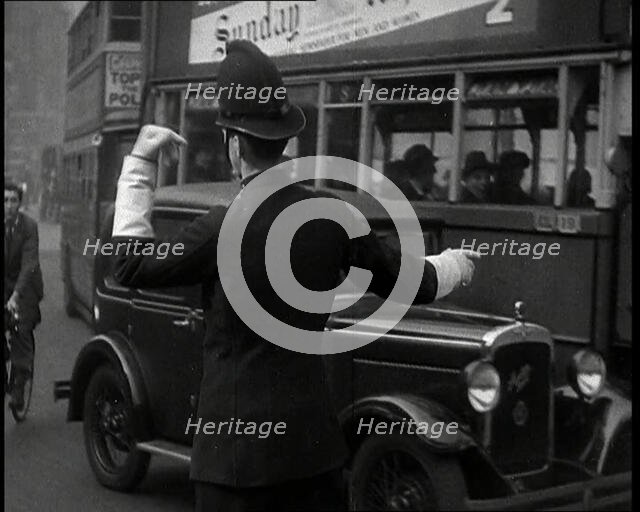 A Police Officer Guiding Traffic on the Streets of London, 1936. Creator: British Pathe Ltd.