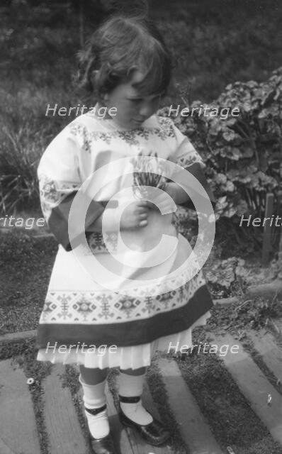 Unidentified child, standing outdoors, between 1911 and 1942. Creator: Arnold Genthe.
