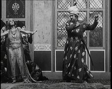 Scene from the Play 'Hassan': the Actor Henry Ainley in Full Costume Raising a Sword..., 1920s. Creator: British Pathe Ltd.