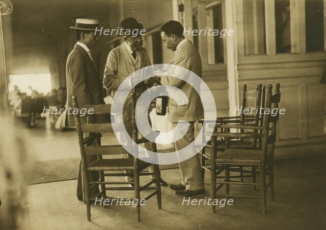 Two Japanese men and one American(?) man, probably journalists, conversing on the veranda..., 1905. Creator: Unknown.