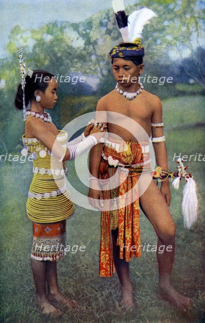 'Young Iban or Sea Dayaks people in gala attire, Borneo', 1922. Artist: Dr Charles Hose
