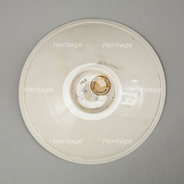 A shallow cream glazed bowl with rolled rim andraised footrim, Tang dynasty, c.800-900. Artist: Unknown.