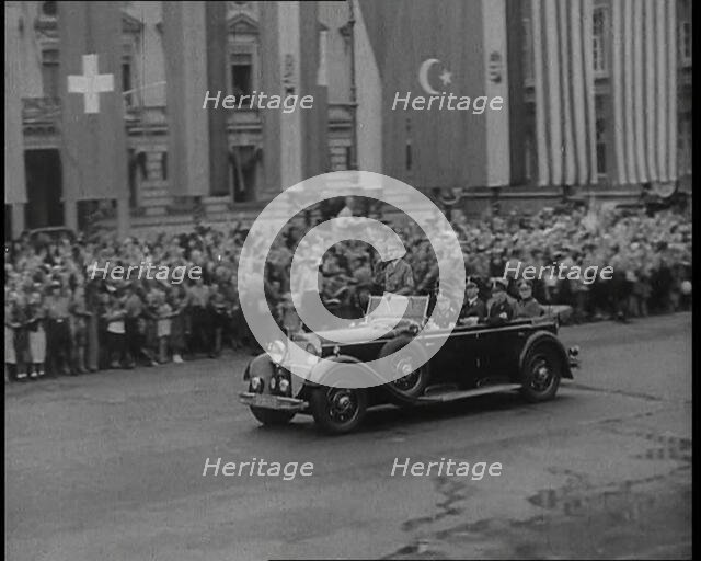 Crowds Watching a Car Drive Through Berlin, 1936. Creator: British Pathe Ltd.