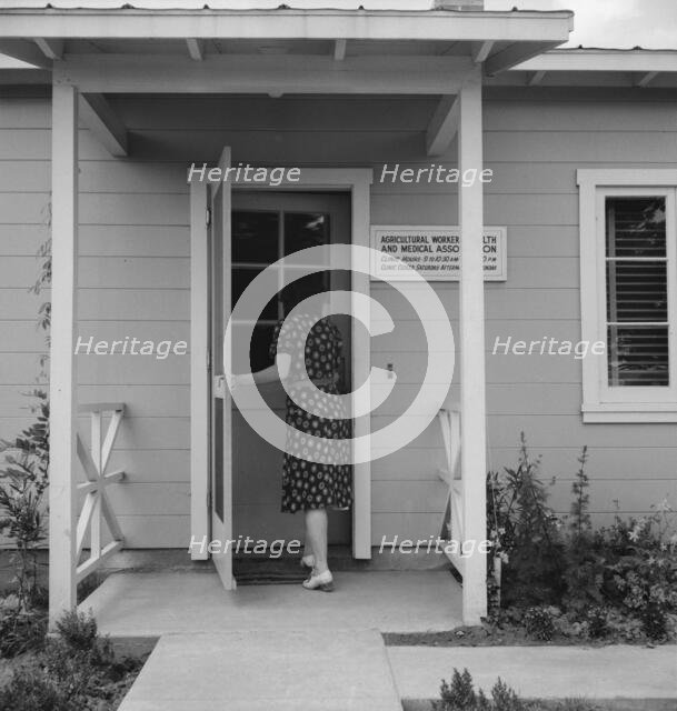 Nurse's help with sick baby, FSA camp, Farmersville, Tulare County, California, 1939. Creator: Dorothea Lange.