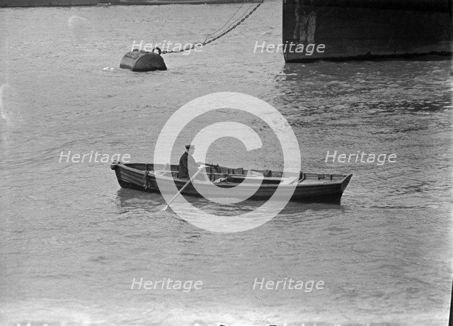 A man rowing a boat in London docks, c1945-c1965. Artist: SW Rawlings