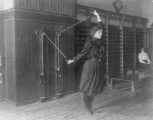 Female student exercising with a wall-mounted device using ropes and..., Washington, DC, (1899?). Creator: Frances Benjamin Johnston.