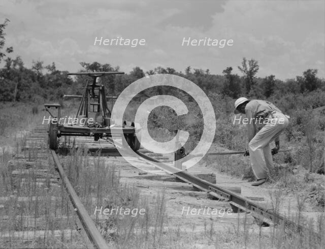 Pulling out the railroad tracks which lead to the closed sawmill, Careyville, Florida, 1937. Creator: Dorothea Lange.