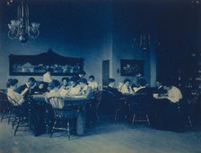 Students seated around tables, studying, at Western High School, Washington, D.C., (1899?). Creator: Frances Benjamin Johnston.