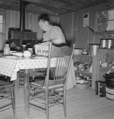 Mrs. Wardlow bakes her own bread in her dugout house, Dead Ox Flat, Malheur County, Oregon, 1939. Creator: Dorothea Lange.