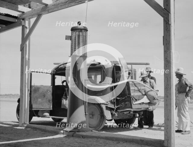 Family...from Fort Smith, Arkansas, trying to repair their car..., Arizona, 1937. Creator: Dorothea Lange.