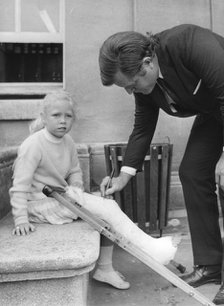 Senator Edward Kennedy signs a girl's leg cast at Radcliffe Infirmary, Oxford, 1971. Artist: Unknown