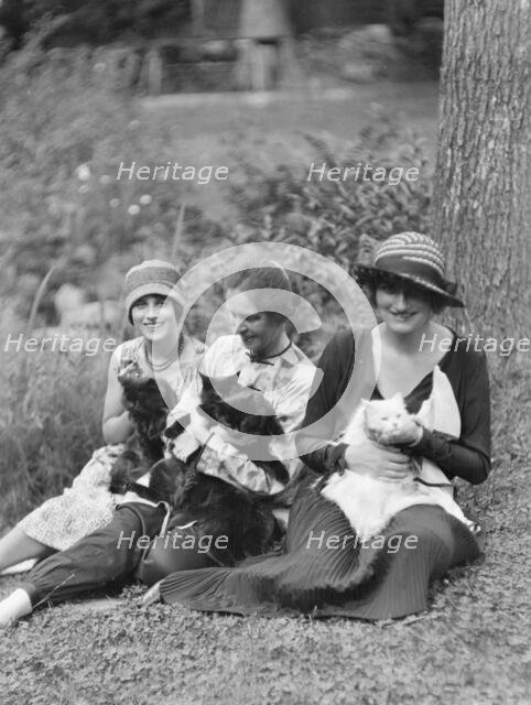 Egger, Gabrielle, Miss, and friends, with cats, seated outdoors, between 1926 and 1930. Creator: Arnold Genthe.