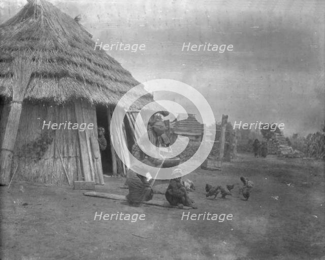 Group of Ainu outside a hut, 1908. Creator: Arnold Genthe.