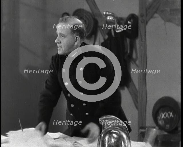 A Close up of Comedian Robb Wilton on Set Playing a Fire Brigade Officer and Standing at a..., 1938. Creator: British Pathe Ltd.