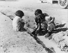 Mexican children playing in ditch, near Corcoran, California, 1936. Creator: Dorothea Lange.
