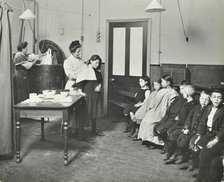 Nurse cutting children's verminous hair, Finch Street Cleansing Station, London, 1911. Artist: Unknown.
