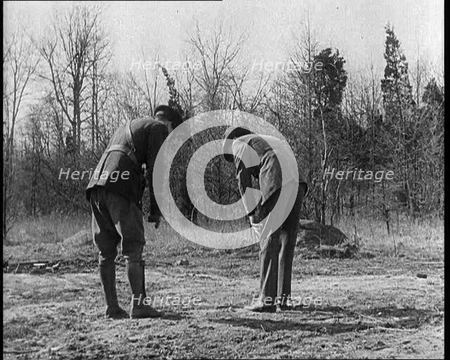Male American Police Officers Investigating Footprints Outside American Aviator Charles..., 1930s. Creator: British Pathe Ltd.