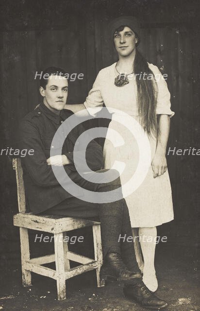 Two prisoners of war, one in drag, pose with a chair, [between 1910 and 1919?]. Creator: Unknown.