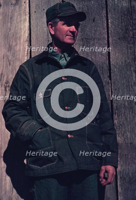 Man in bill cap and dungaree coat, possibly a farmer, between 1941 and 1942. Creator: Unknown.