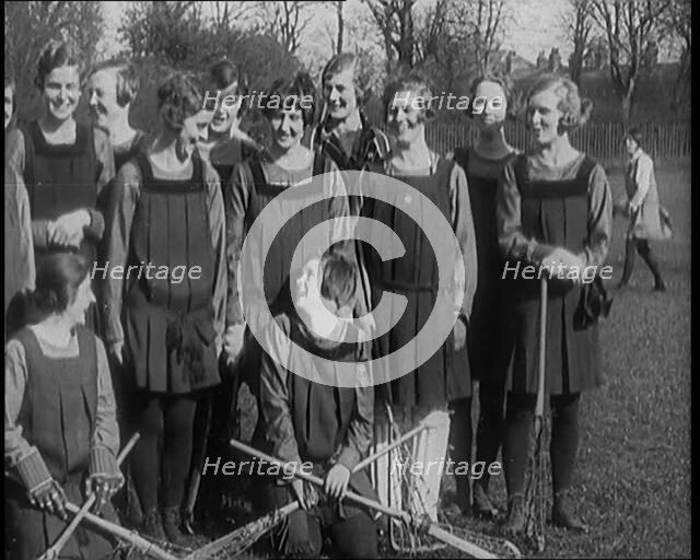 A Group of Young Female Civilians Wearing Gymslips Holding Lacrosse Sticks, 1920. Creator: British Pathe Ltd.