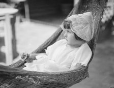 Rice, Isaac, Mrs., grandaughter of, in a hammock, 1920 July 26. Creator: Arnold Genthe.