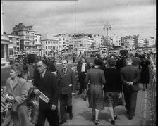 A Cloudy Day as Male and Female Pedestrians are Walking on the Promenade at  Brighton..., 1939. Creator: British Pathe Ltd.