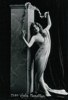 Viola Hamilton, posing in a classical attitude against a square column, early 20th century. Creator: Unknown.