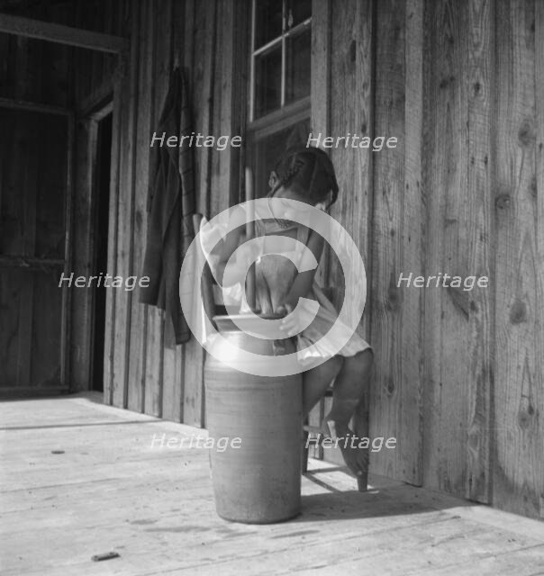 Daughter of Negro tenant churning butter. Randolph County, North Carolina, 1939. Creator: Dorothea Lange.