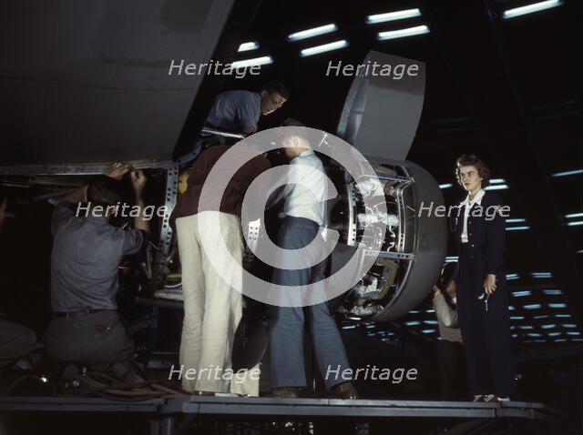 Installing an engine at the Consolidated Aircraft Corporation plant, Fort Worth, Texas, 1942. Creator: Howard Hollem.