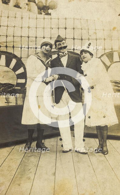 Three sailors, two in drag wearing pierrette costumes, pose on deck, c1910s. Creator: Unknown.