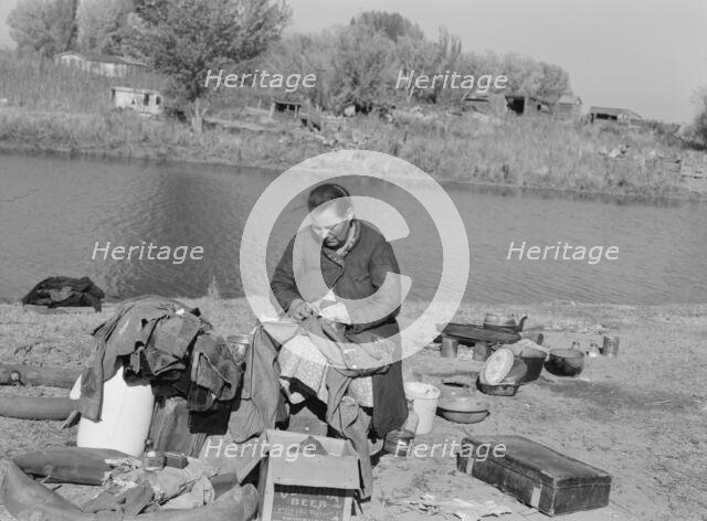 Mother of migrant family sewing, near Vale, Malheur County, Oregon, 1939. Creator: Dorothea Lange.